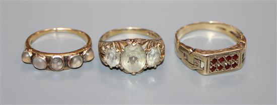 An 18ct yellow metal and moonstone half hoop ring (a.f.) and two 9ct gold and gem set rings.